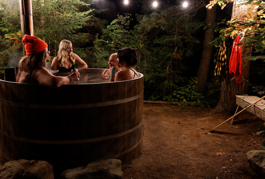 girls sitting in a woodstove fire hot tub in norther ontario