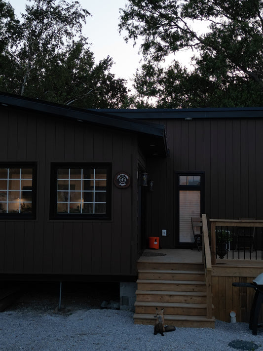 willow barrel retreat fox den suite with a fox kit sitting in front with a chilly moose cooler on the deck