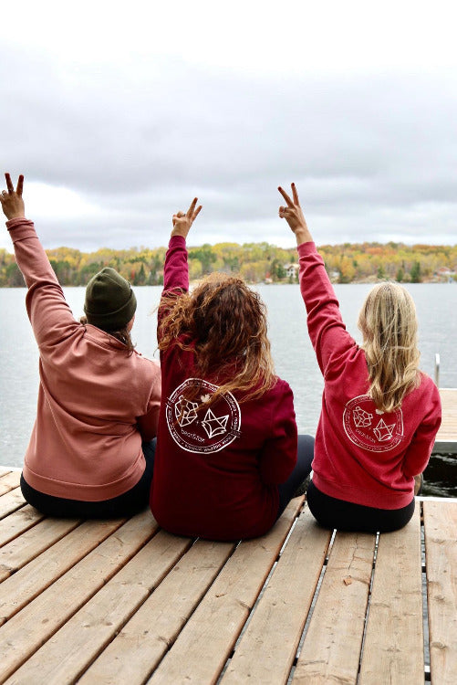 three canadian women sitting on the dock throwing deuces