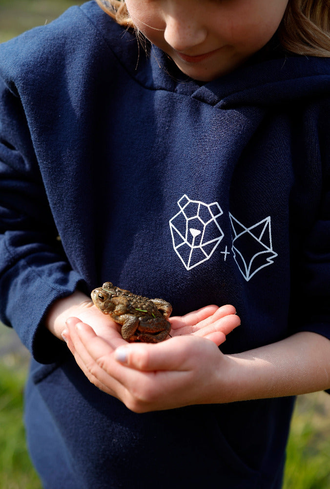 youth girl holding a toad in the cub hoodie at willow lake campground