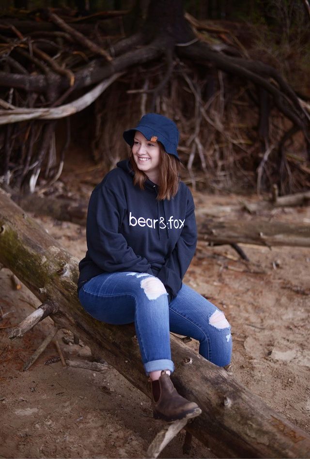 Bear and Fox Apparel black hinterland whos who hoodie canuck girl outside in bucket hat at the cottage